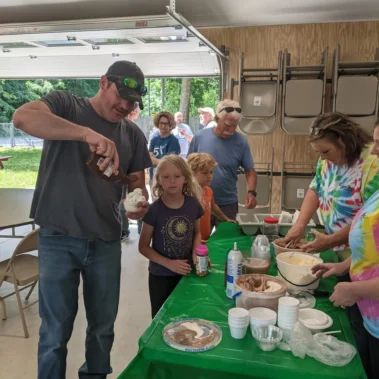 man and children making ice cream sundaes