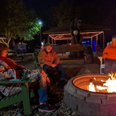 adults sitting around campfire